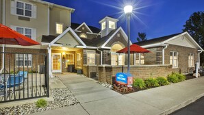 A two-story building with a welcoming entrance, a mailbox, and outdoor seating. - TownePlace Suites by Marriott Detroit Dearborn (Dearborn)