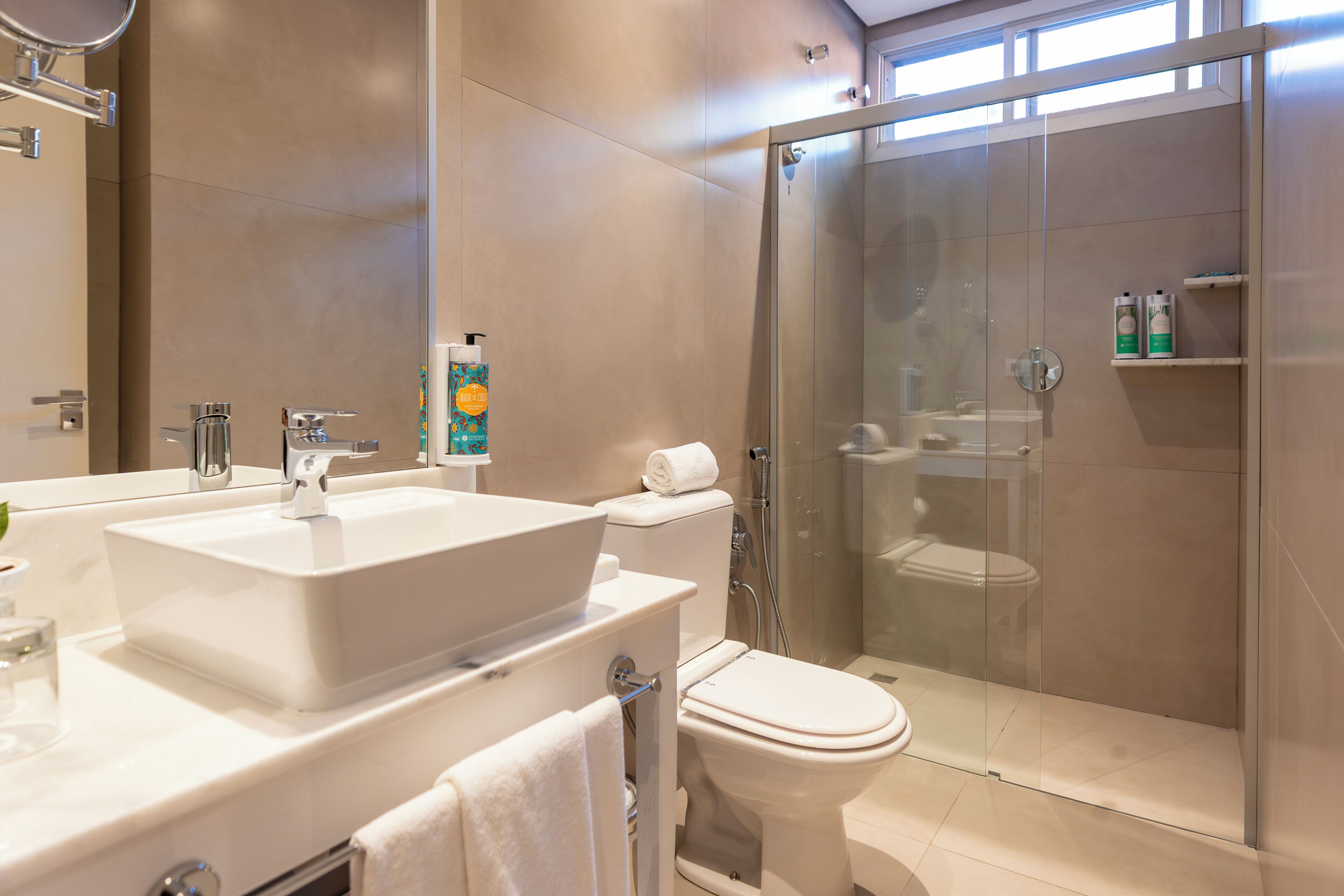 Une salle de bain moderne avec un grand lavabo, des toilettes et une douche à parois de verre.