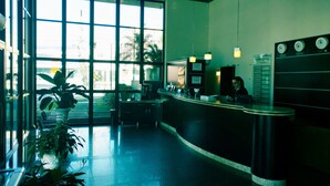 A reception area with a counter, a clock, and a menu board. - Brisamar Suite Hotel (Florianópolis)