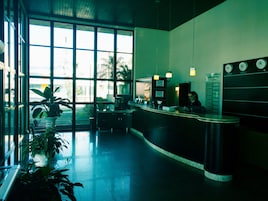 Una zona de recepción con un mostrador, un reloj y una pizarra de menú.