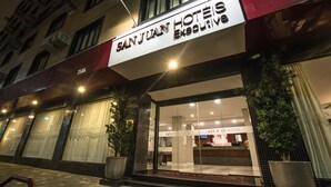 San Juan Hotels' facade med store vinduer og et synligt receptionsområde indeni.