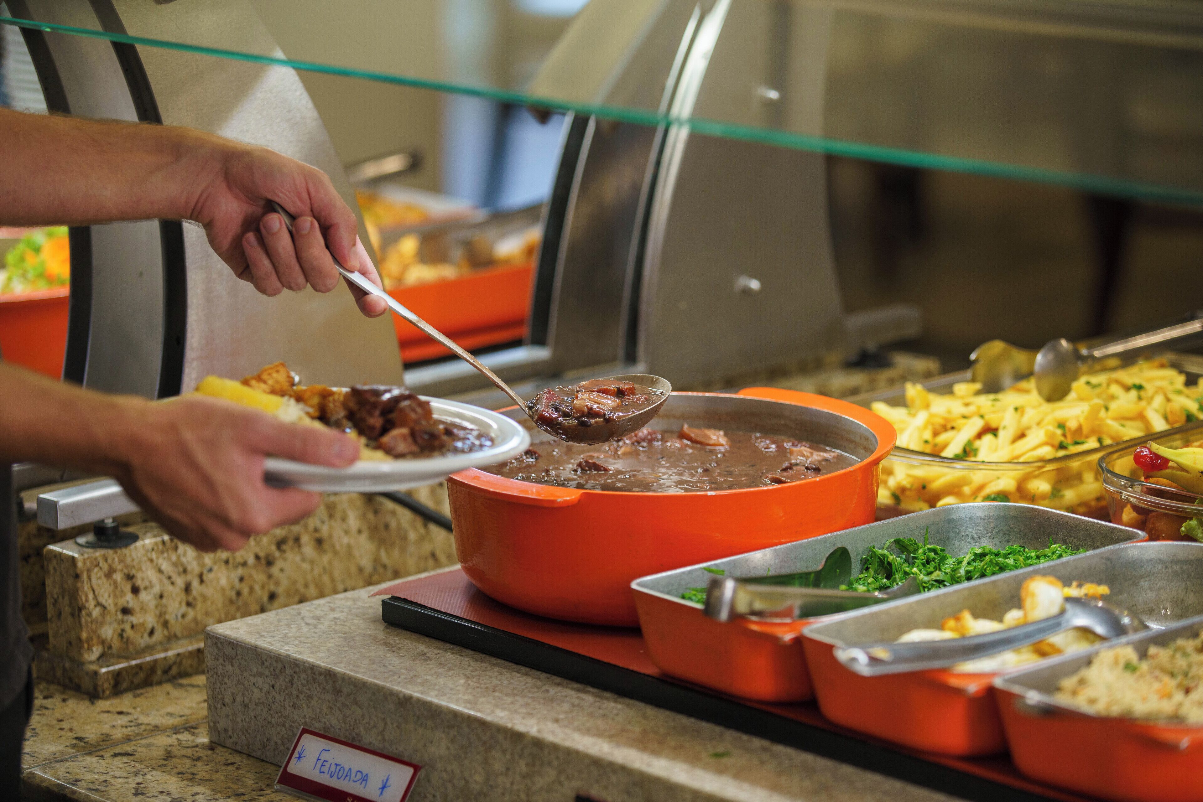 Een buffet met diverse gerechten, waaronder een stoofpot en schalen met eten.