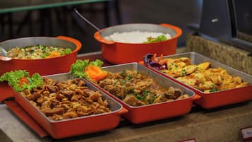 Un bufé con diversos platos, incluyendo arroz, carne y verduras.