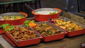 Un bufé con diversos platos, incluyendo arroz, carne y verduras.