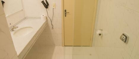 Un baño moderno con cabina de ducha de vidrio, un lavamanos con espejo y un inodoro.