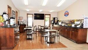 A breakfast area with wooden cabinets, a coffee station, and a buffet counter. - Baymont by Wyndham Pierre (Pierre)