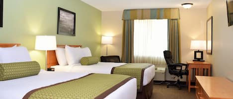 Een hotelkamer met twee bedden, een bureau, een stoel en een foto aan de muur.