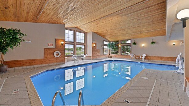 Una piscina interior con techo de madera, suelo de baldosas y un cartel que indica 'No Diving Allowed'.