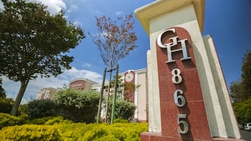 A hotel entrance with a prominent sign displaying the name and address.