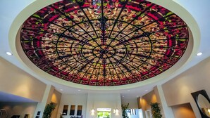 A large circular stained glass ceiling with a floral pattern. - The Grand Hotel (Sunnyvale)