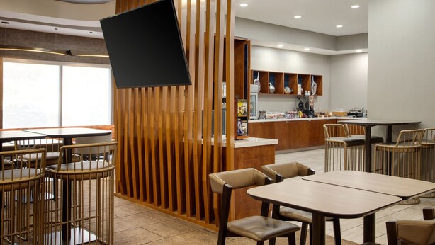 Ein modernes Restaurant-Interieur mit Holzwänden, einer Bar und verschiedenen Sitzgelegenheiten.