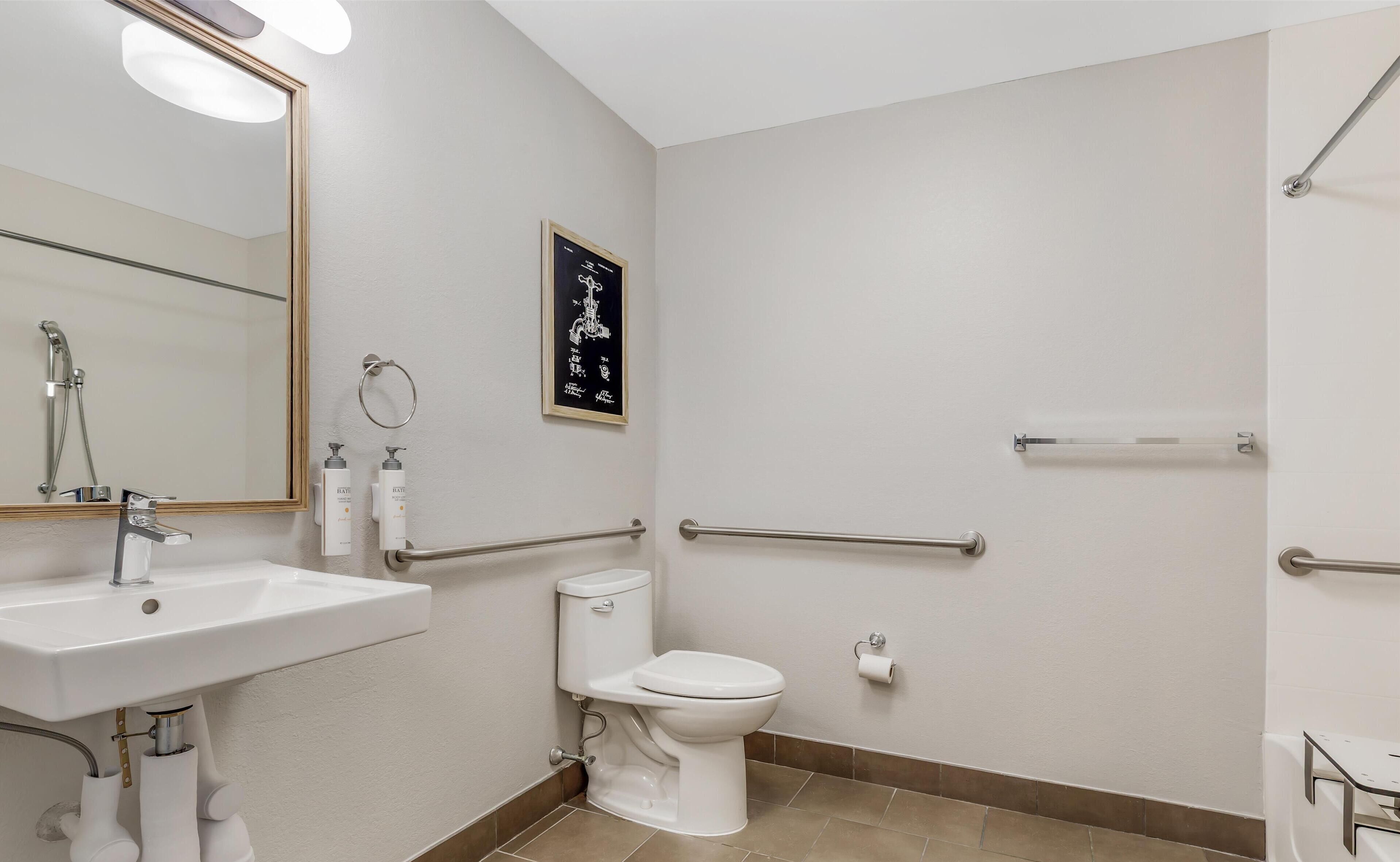 A modern bathroom with a sink, toilet, and shower.