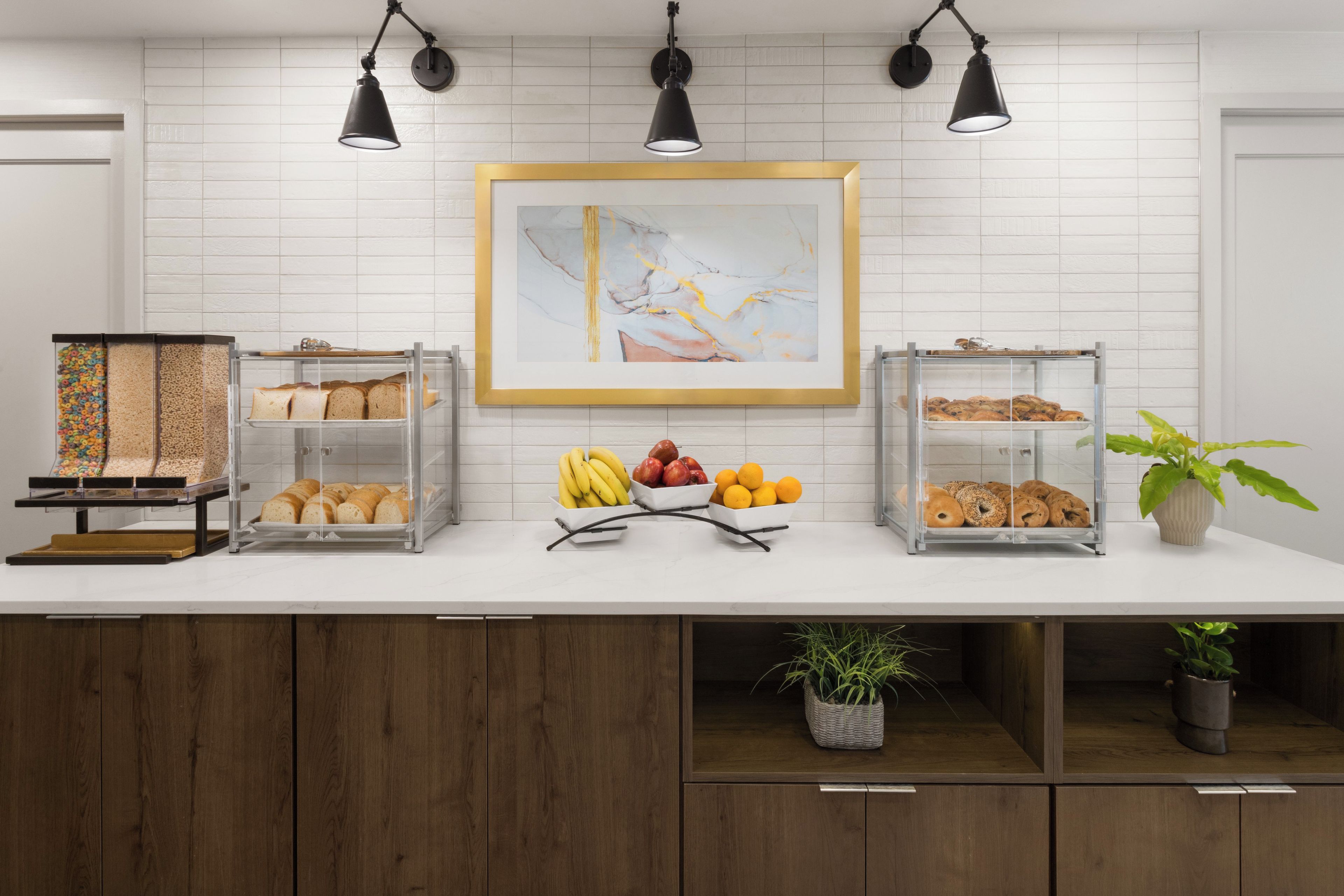 A breakfast bar with a variety of breads, fruits, and pastries.