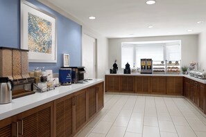 A modern kitchen with a white countertop, wooden cabinets, and a coffee station. - Staybridge Suites Boston - Burlington by IHG (Burlington)