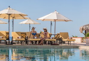 Ein Poolbereich mit Liegestühlen und Sonnenschirmen.