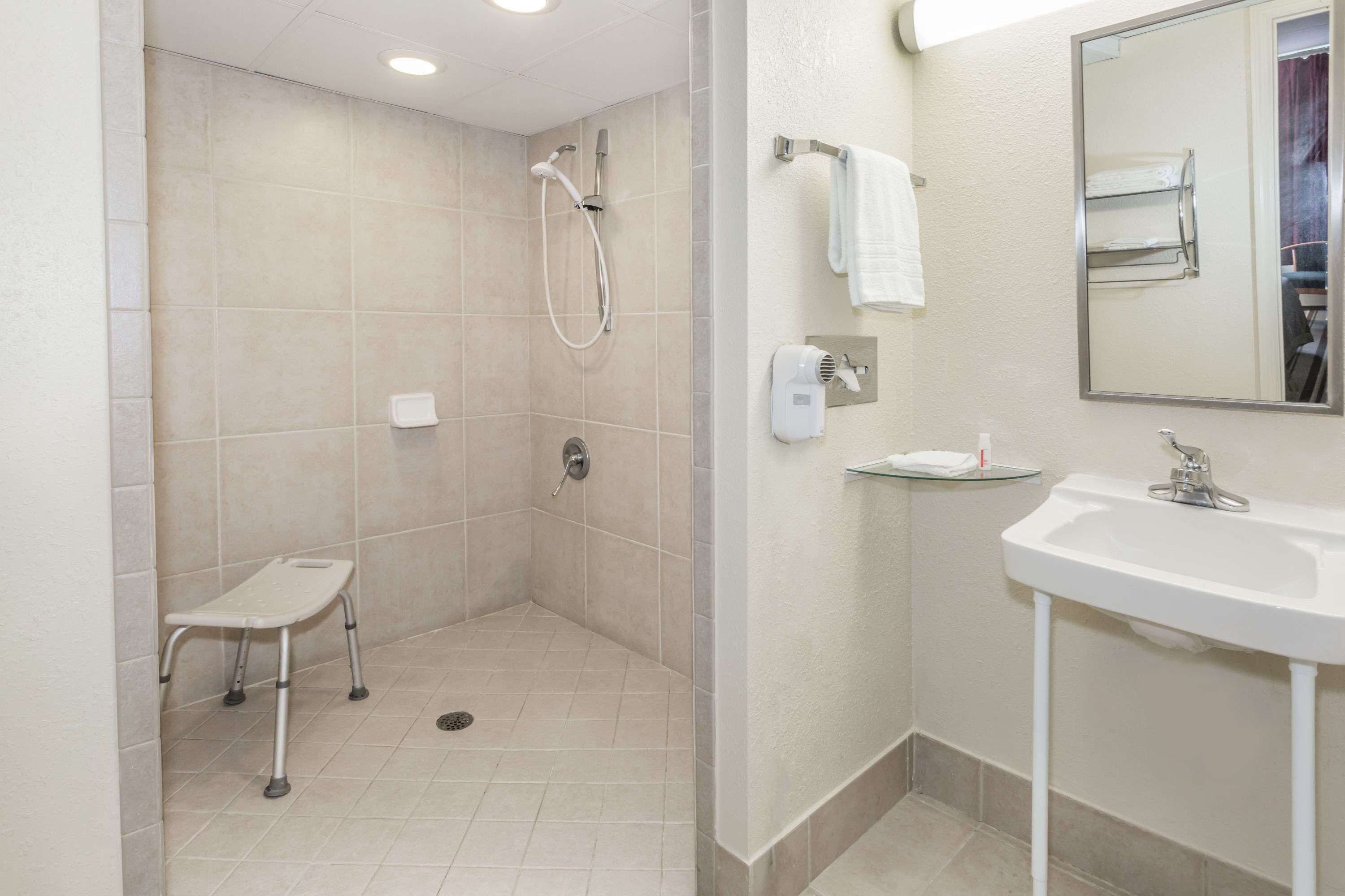 Een moderne badkamer met een douche, een wastafel en een handdoekhouder.