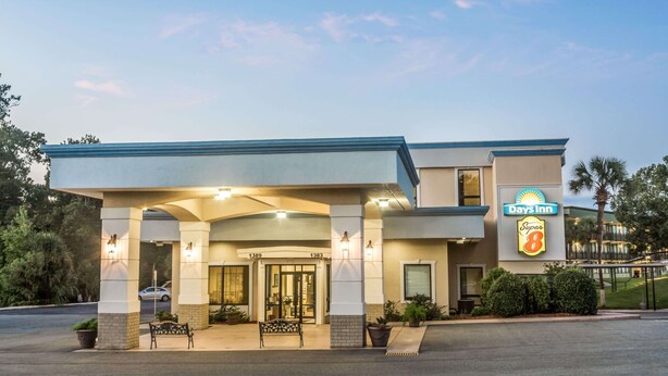 Un hotel Days Inn con entrada cubierta, asientos al aire libre y un letrero que indica la marca Super 8.