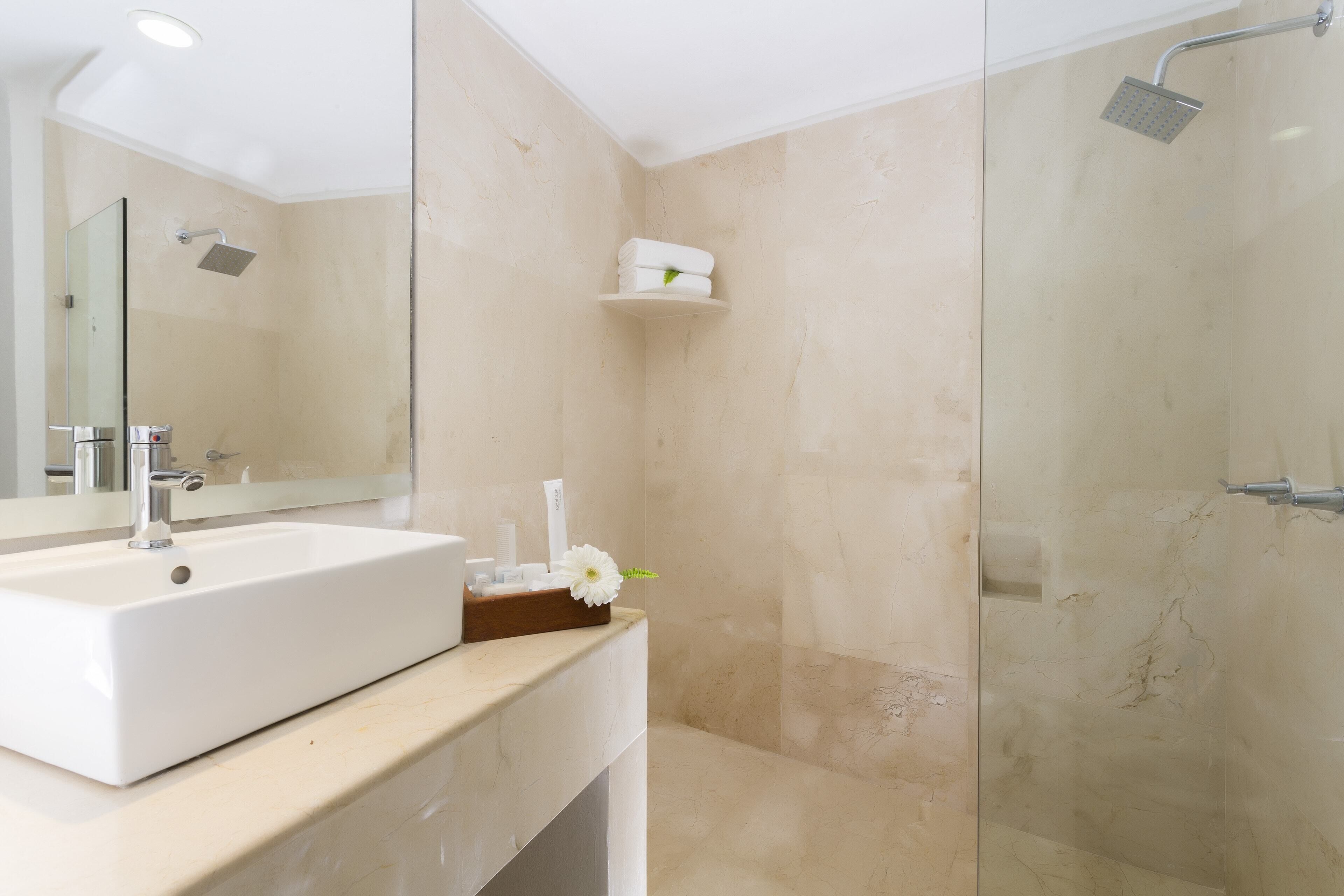 Een moderne badkamer met een groot wastafel, spiegel en douche.