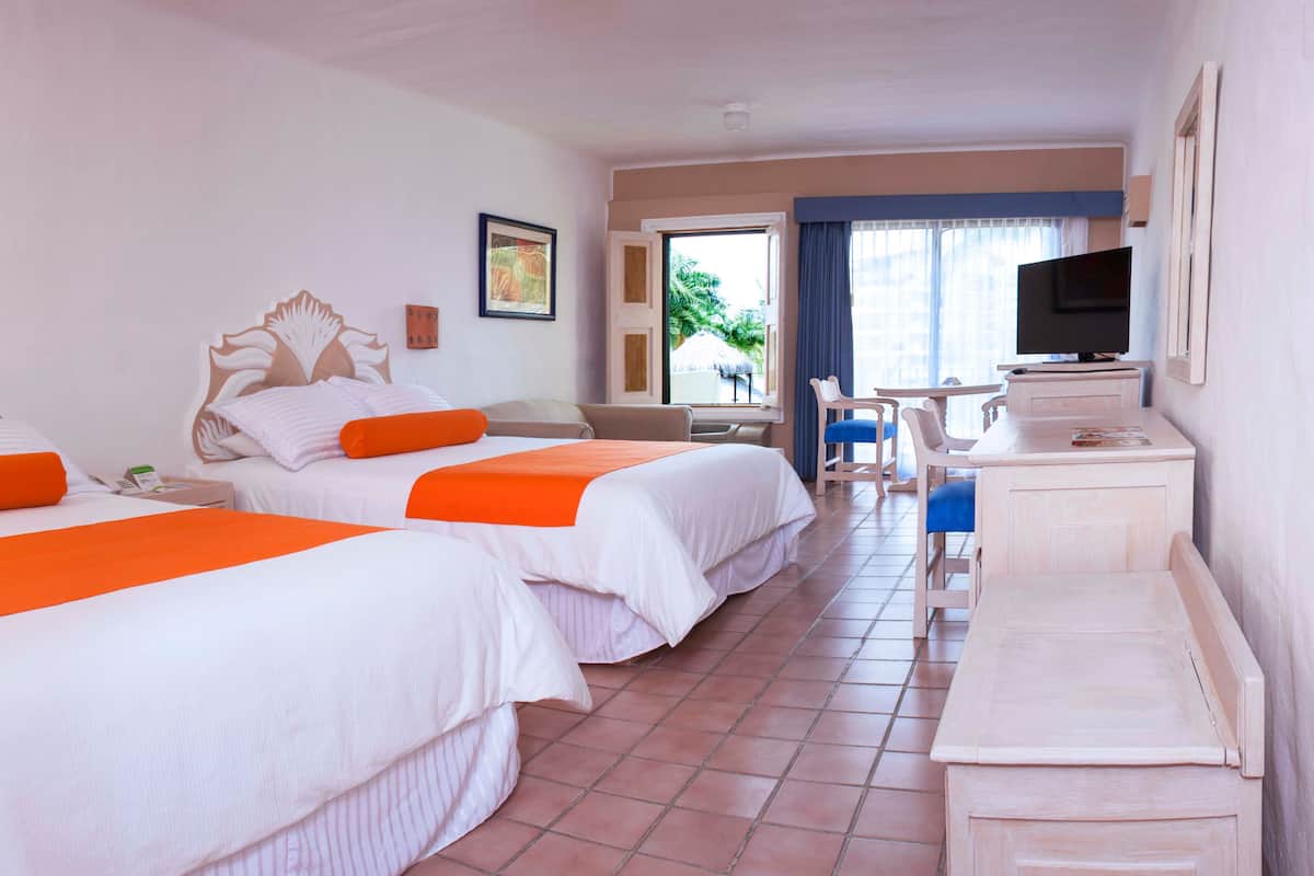Une chambre d’hôtel avec deux lits, un bureau, une chaise, une télévision et une fenêtre donnant sur l’extérieur.