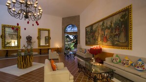 A spacious living room with a chandelier, large mirrors, a painting, and a glass coffee table. - Flamingo Vallarta Hotel & Marina (Puerto Vallarta)
