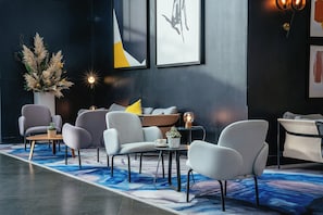 A modern lounge area with seating, a coffee table, and a decorative plant.
