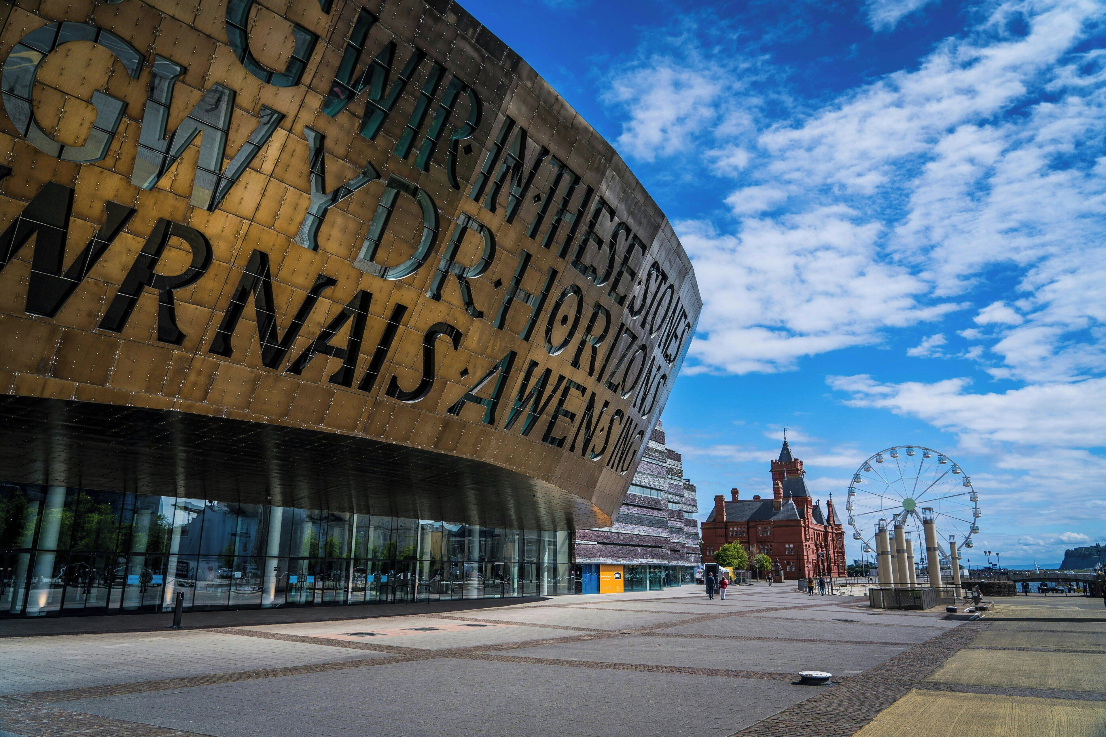 A modern building with a curved facade and large letters spelling out a name.