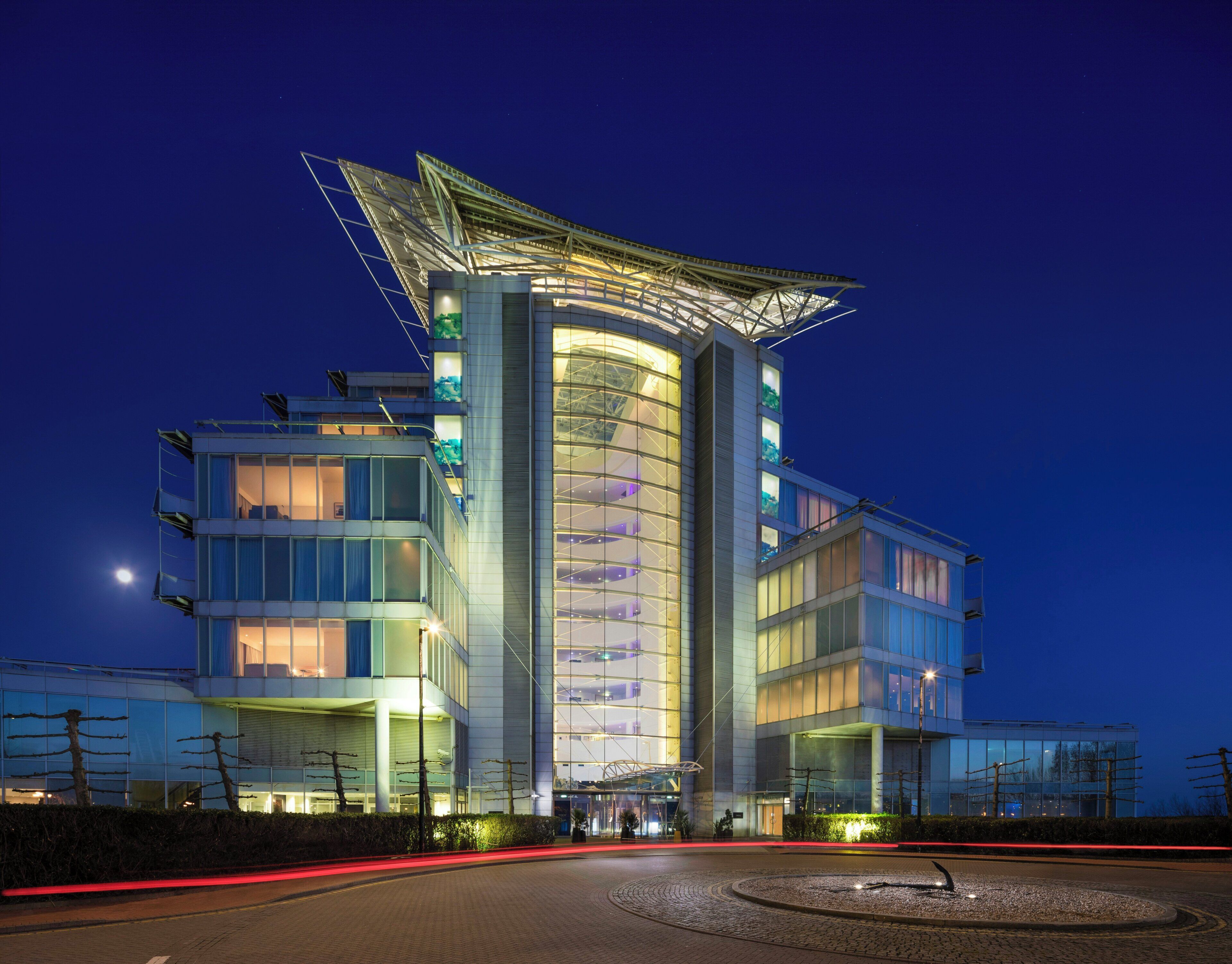 A modern hotel with a distinctive curved facade and a unique rooftop structure.