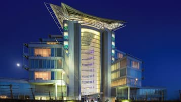 A modern hotel with a distinctive curved facade and a unique rooftop structure.
