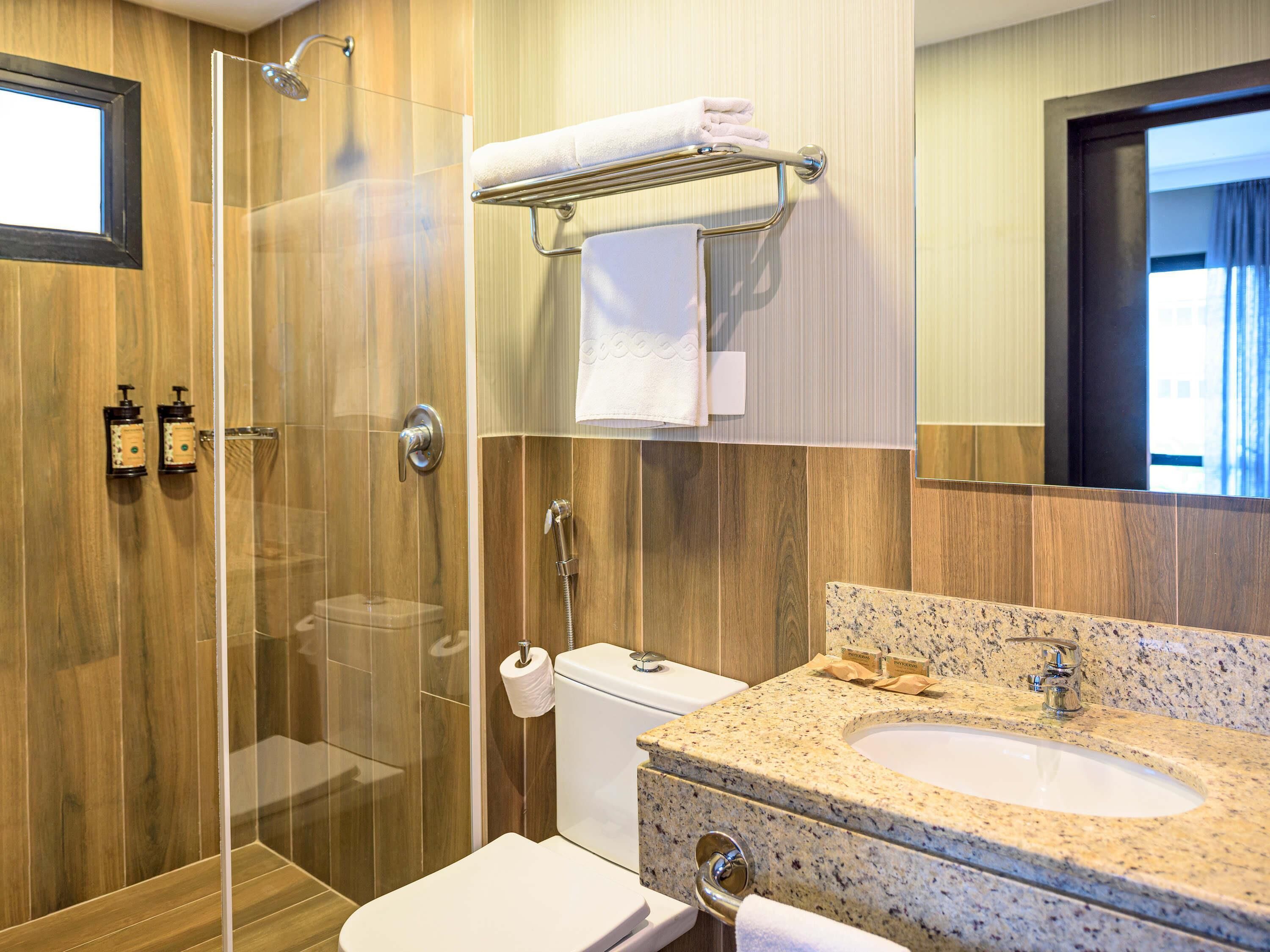 Ein modernes Badezimmer mit einer gläsernen Duschkabine, einem Granitwaschbecken und einer Toilette.
