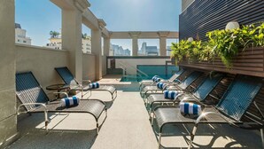 A rooftop pool area with lounge chairs and a view of the city skyline. - Novotel SP Jardins (São Paulo)