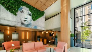 A modern lobby with a large mural, seating areas, and a reception desk. - Novotel SP Jardins (São Paulo)
