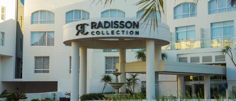 A hotel entrance with a sign reading "Radisson Collection."