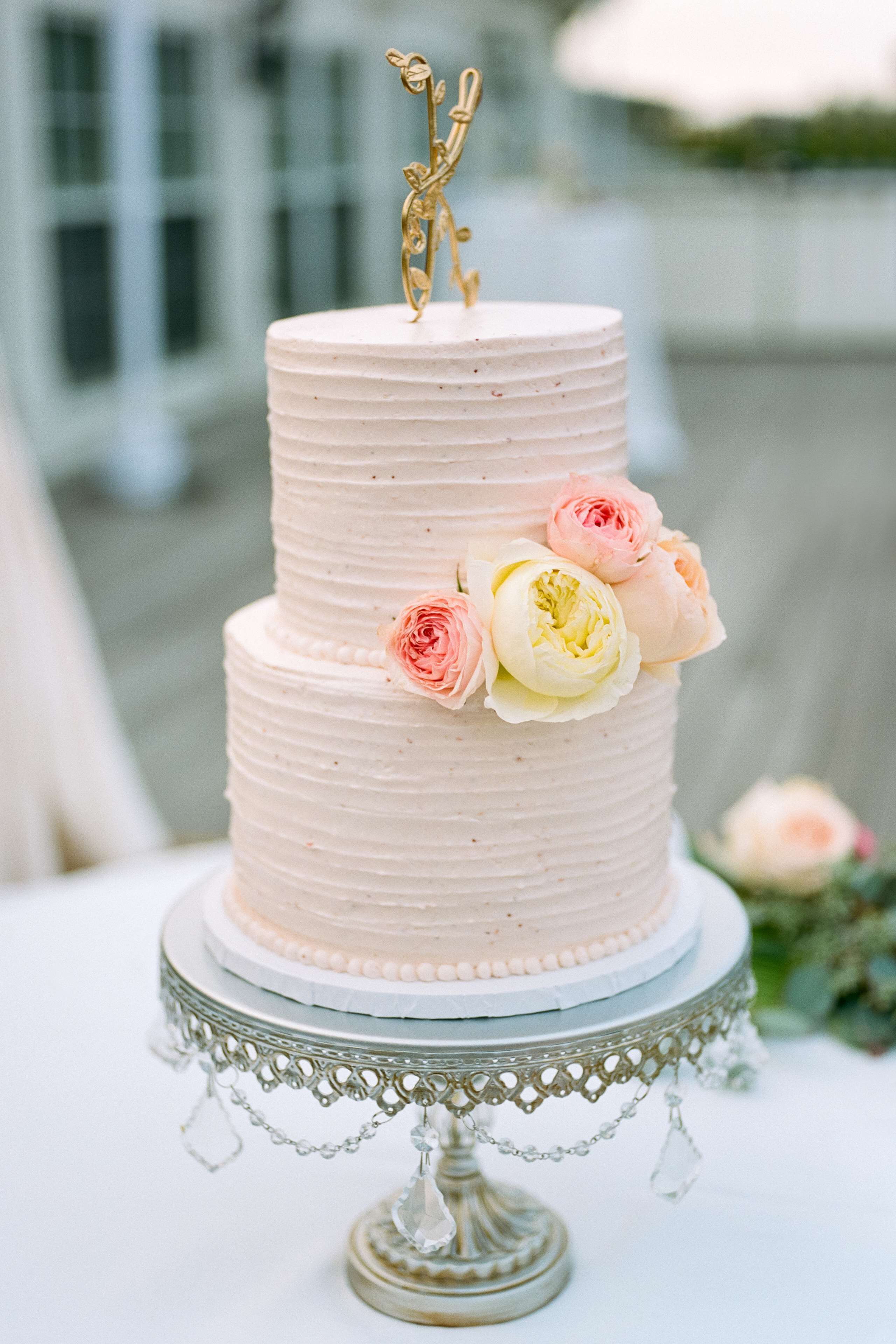 A multi-tiered cake with floral decorations on a decorative stand.