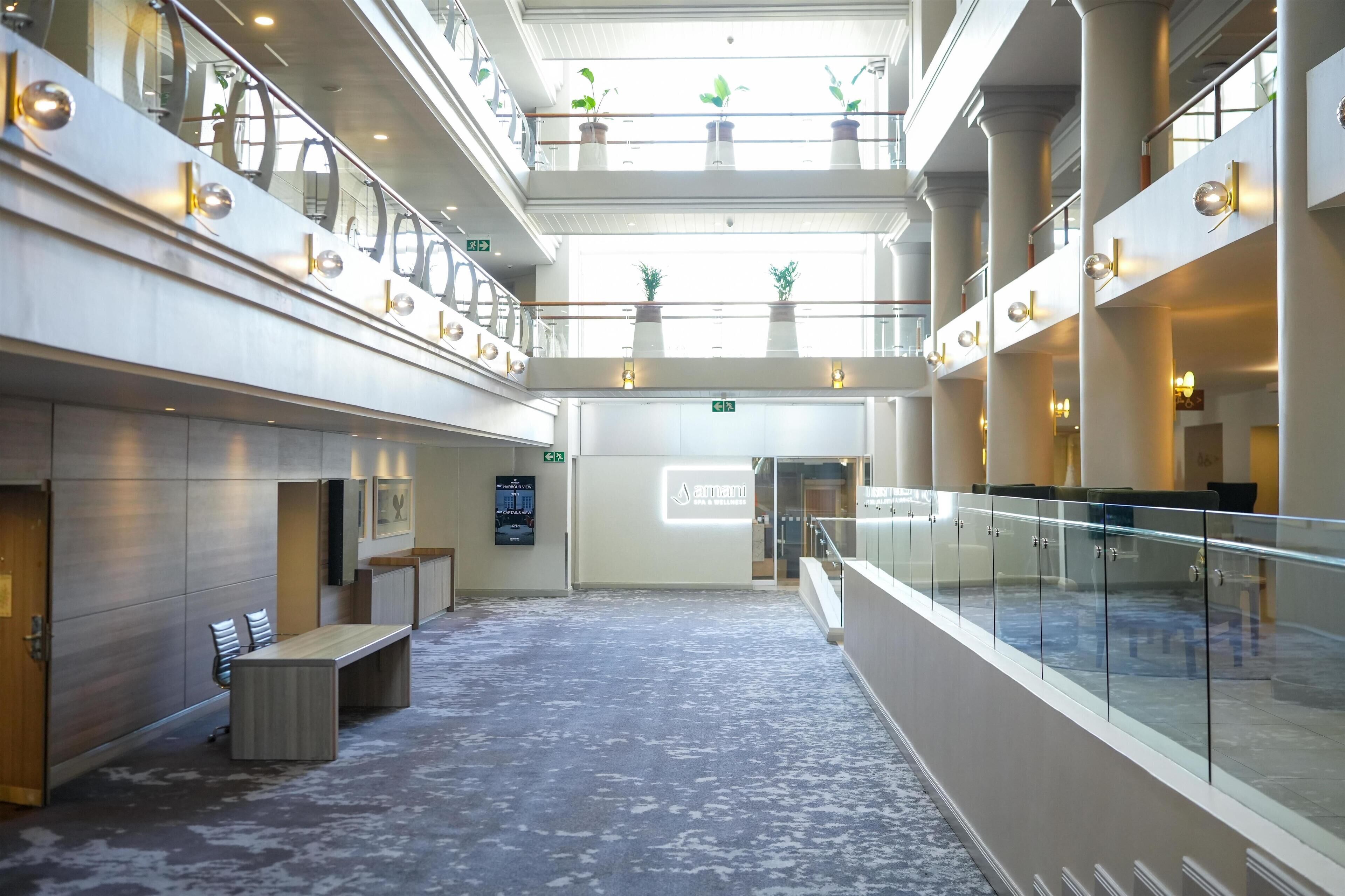 A spacious lobby with a high ceiling, multiple levels, and a central staircase.