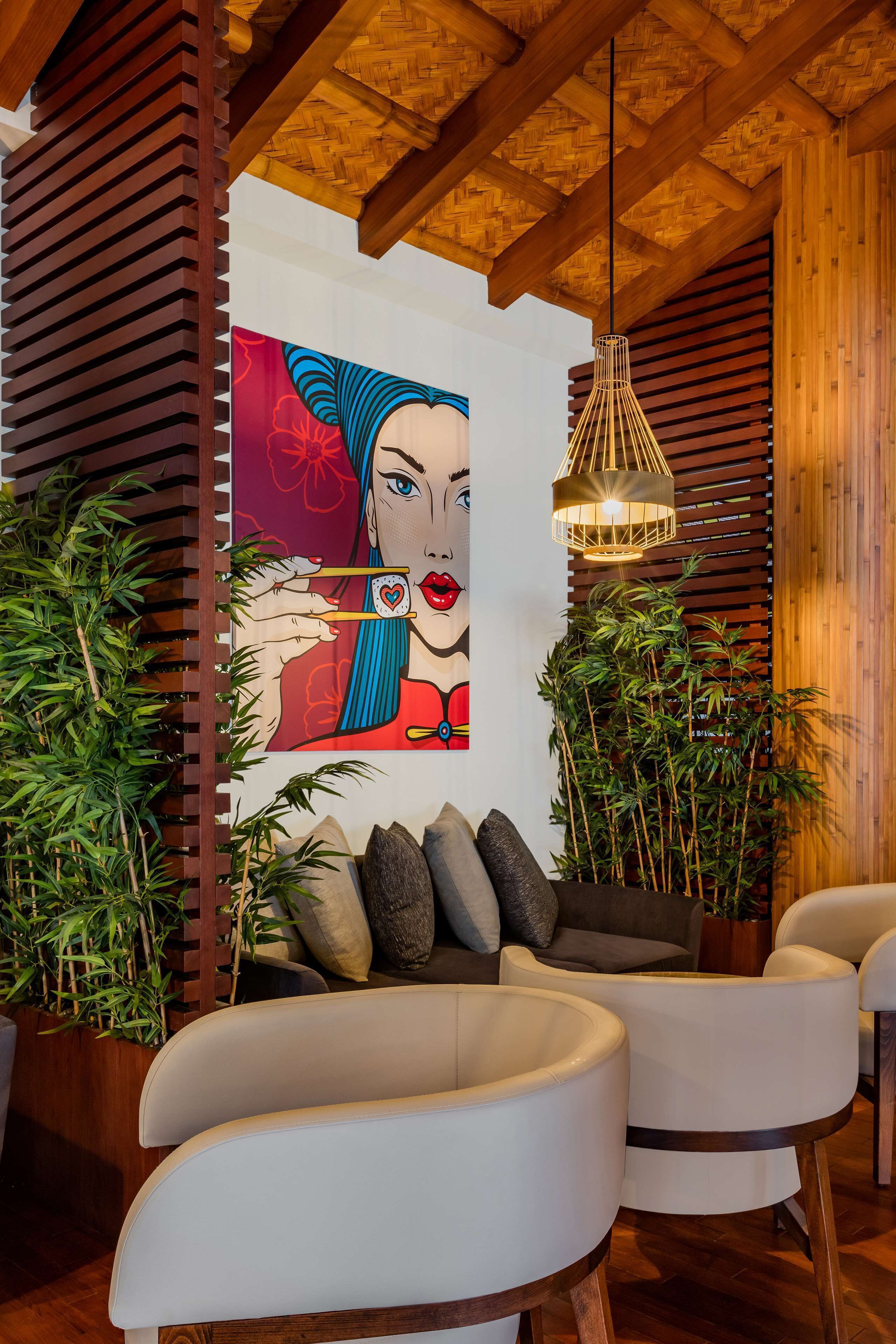 Un interior moderno con techo de madera, un mural grande y una zona de estar con sillas blancas y un sofá.