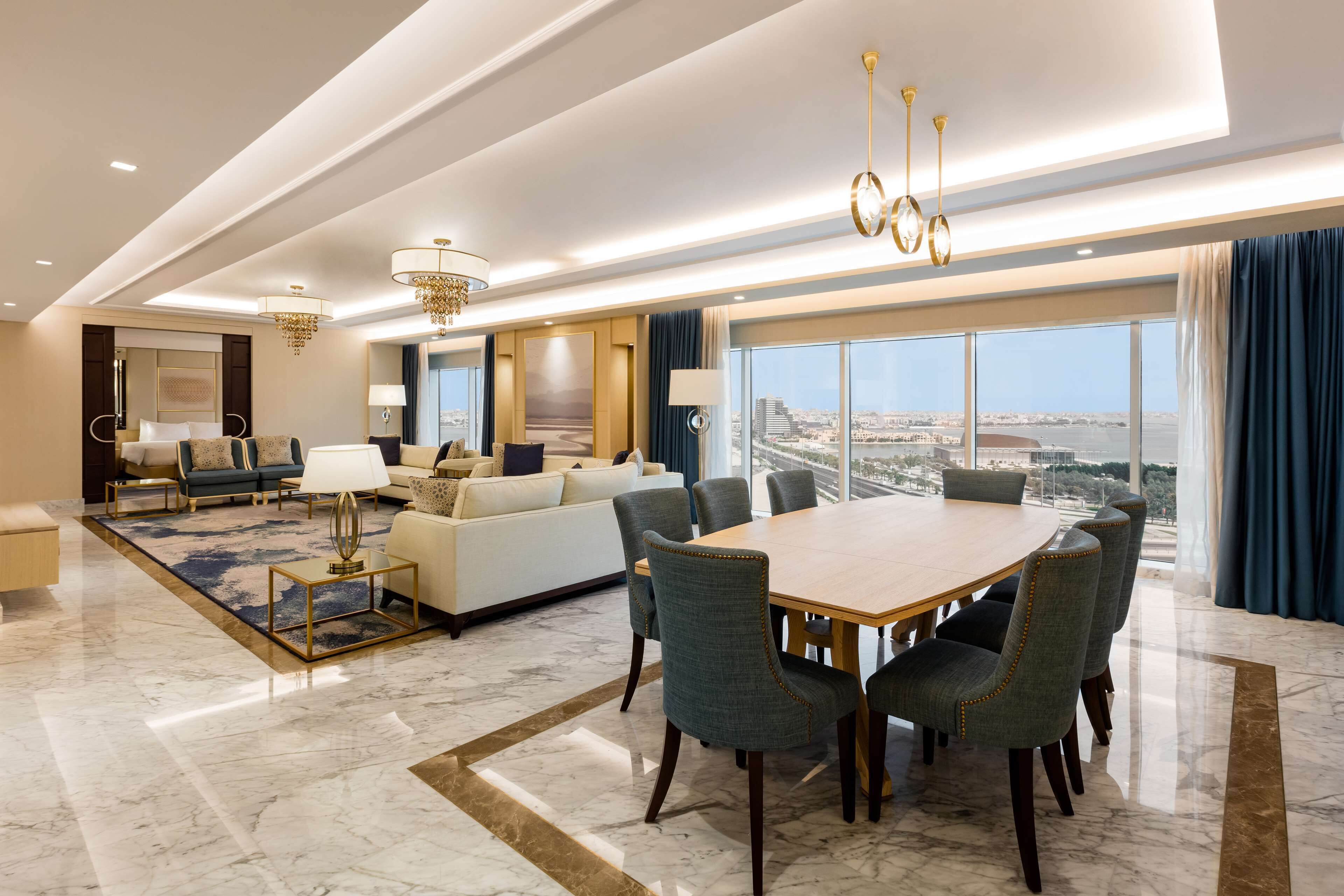 Ampla sala de estar com uma grande mesa de jantar, assentos confortáveis e vista para a cidade através de janelas espaçosas.
