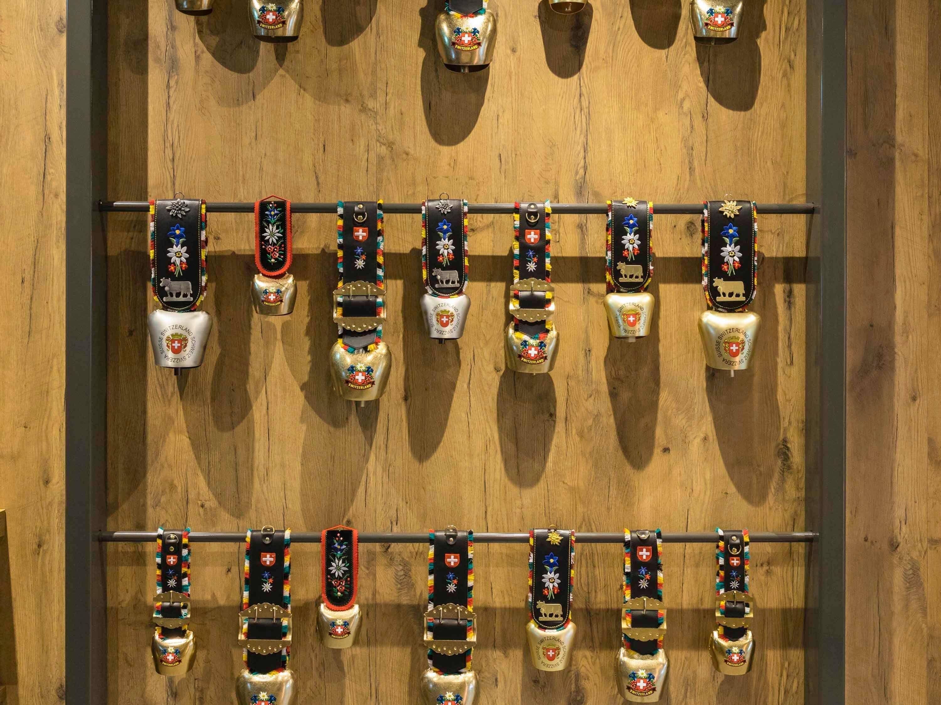 Una pared con varias filas de relojes suizos y colgantes.