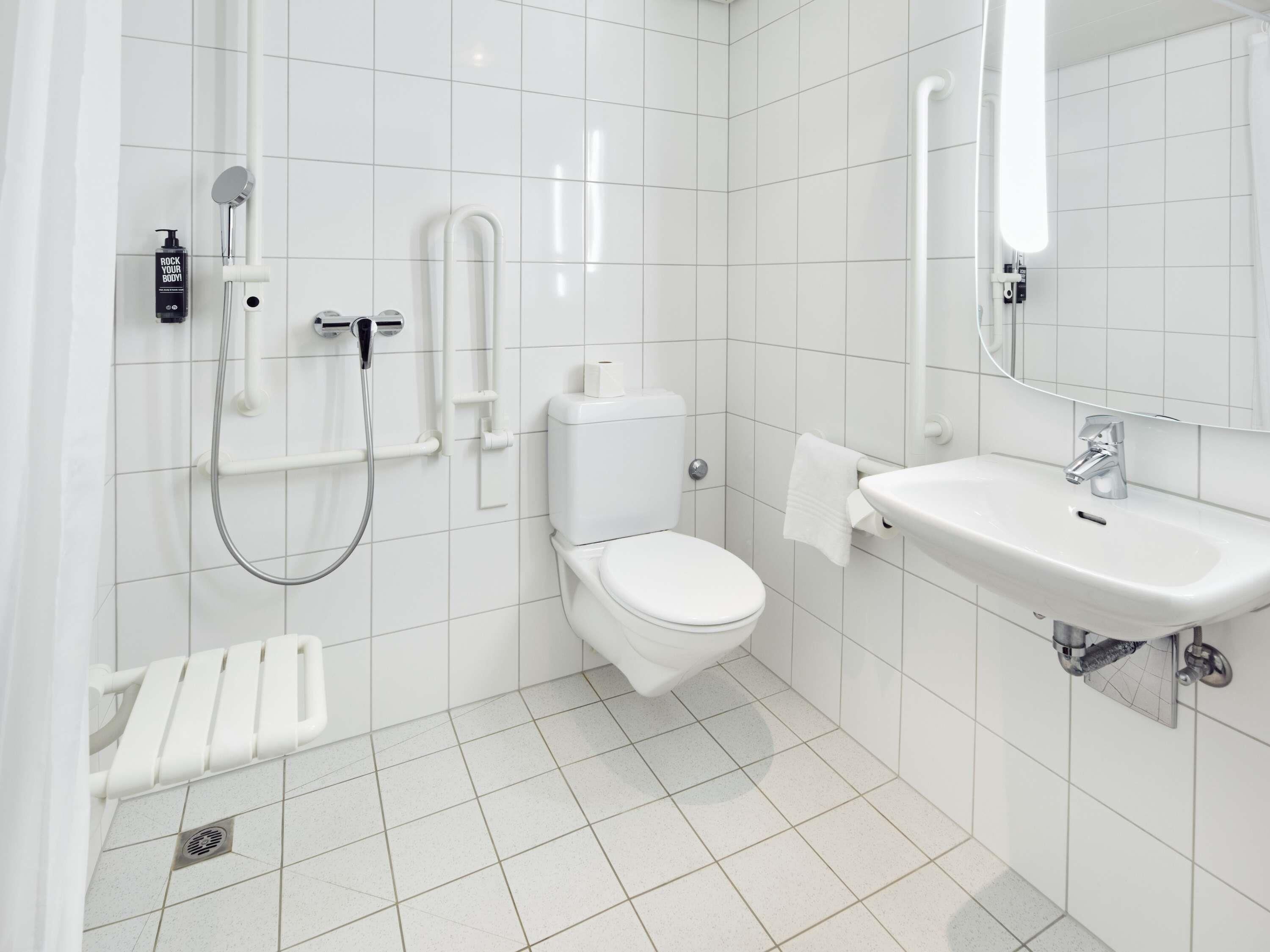 Ein modernes Badezimmer mit Toilette, Bidet, Dusche und Waschbecken.