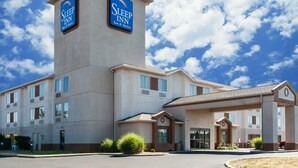 Un hotel Sleep Inn con una torre destacada, múltiples accesos y un exterior bien conservado.