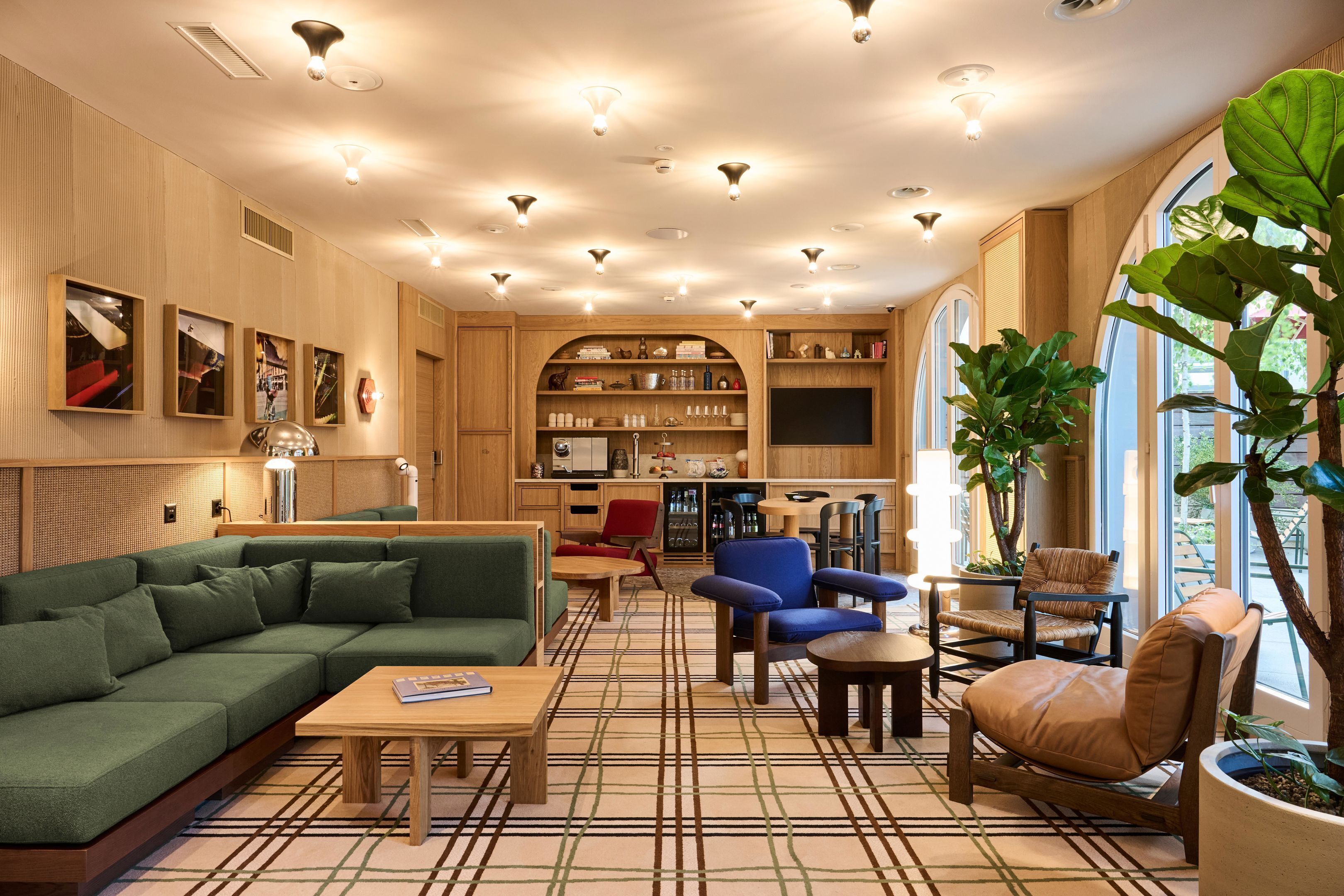 Een moderne woonkamer met een bank, stoelen, een salontafel en een boekenkast.