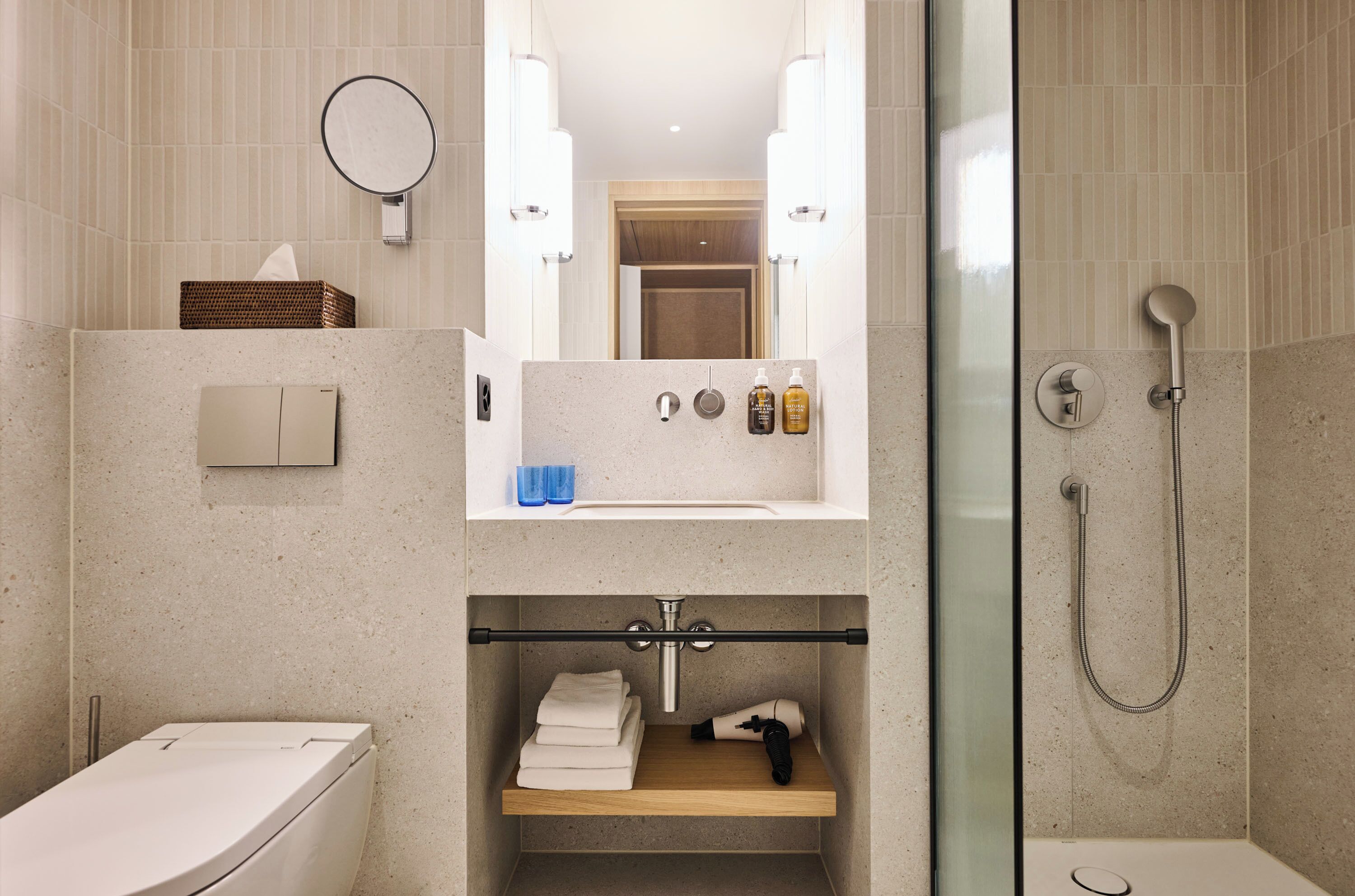 A modern bathroom with a toilet, sink, and shower.