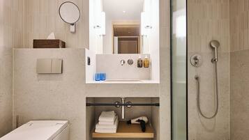 A modern bathroom with a toilet, sink, and shower.