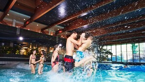 An indoor swimming pool with people playing and splashing water. - Sorell Boutique-Hotel Speer Rapperswil (Rapperswil-Jona)