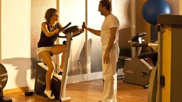 A gym with exercise equipment, including a stationary bike and a rowing machine.
