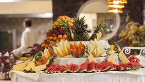 A fruit display with pineapples, watermelon, and other fruits on a table. - Hotel Continental Ischia (Ischia)