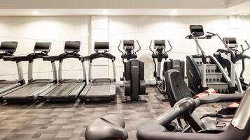 A gym with multiple treadmills, elliptical machines, and exercise bikes.