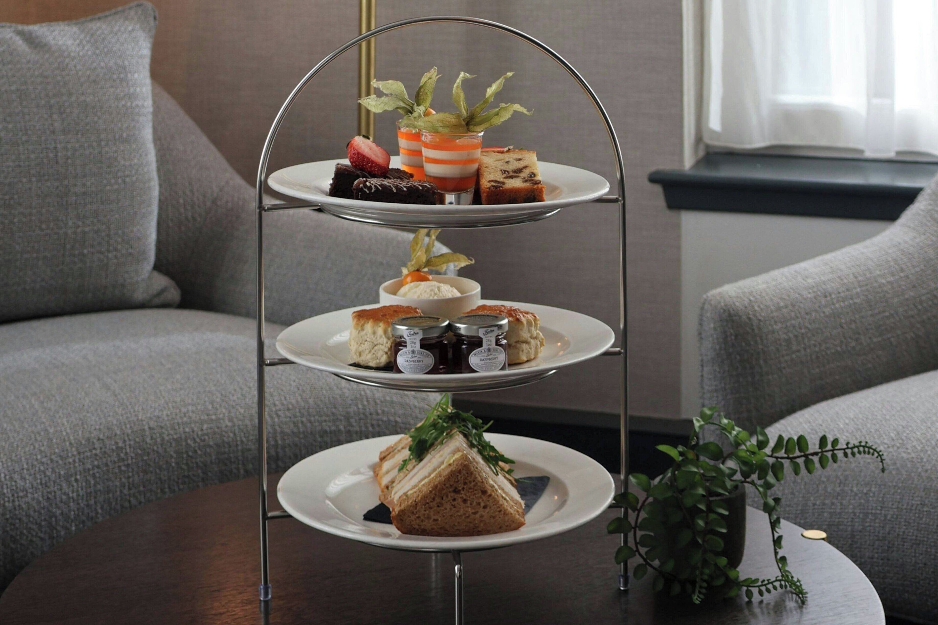 A three-tiered dessert stand with various pastries and desserts.