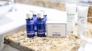 A bathroom vanity with toiletries including Elemis products.