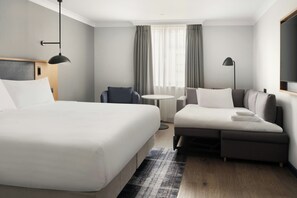 A modern hotel room with a large bed, a sofa, a small round table, and a desk. - Edinburgh Marriott Hotel Holyrood (Edinburgh)