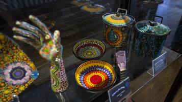 A display of colorful ceramic kitchenware with lids and handles.